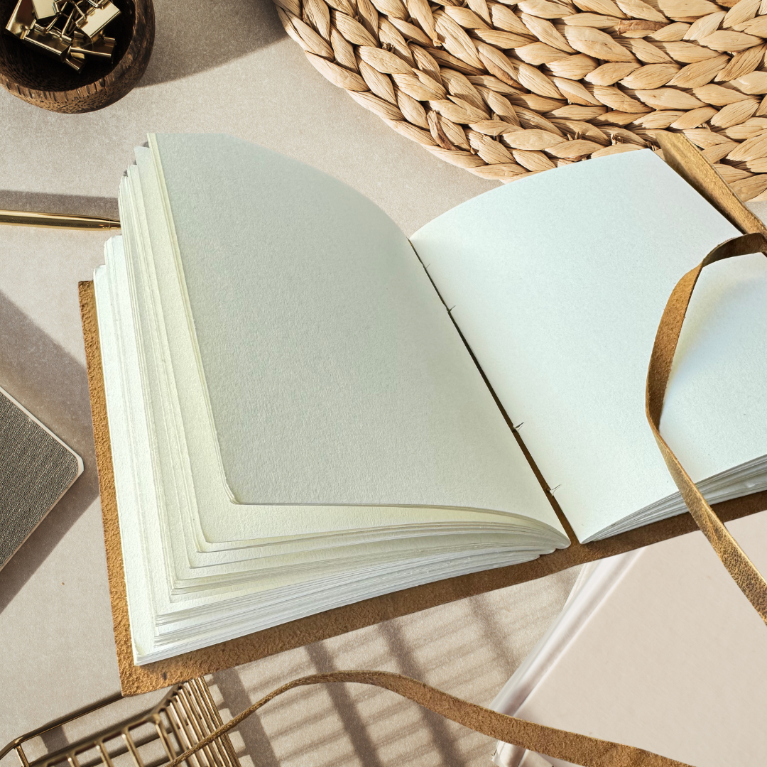 Cassia gift for graduation placed on a asthetic table with sunrays falling on the leather journal
