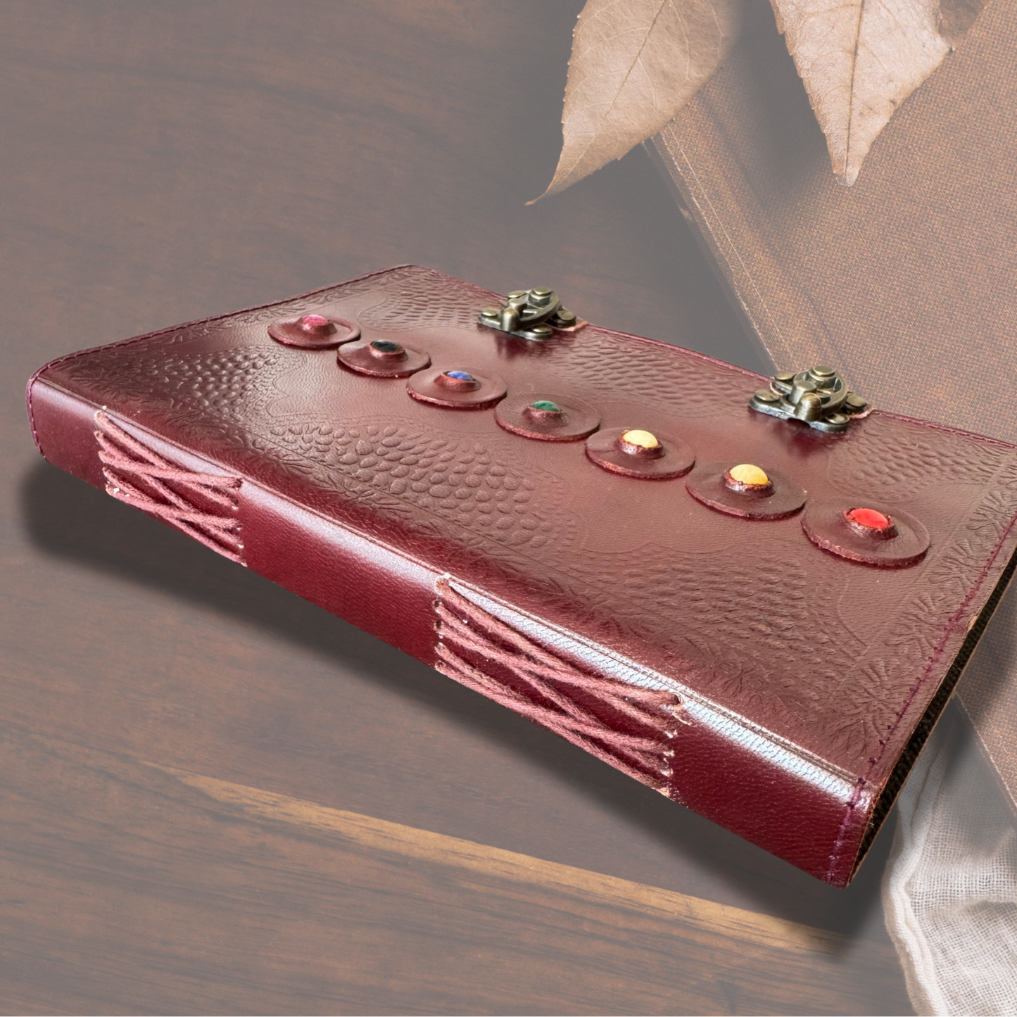 Ember Diary Spell Book dispalyaed on a wooden asthetic background showing the journal is a hand bound journal.