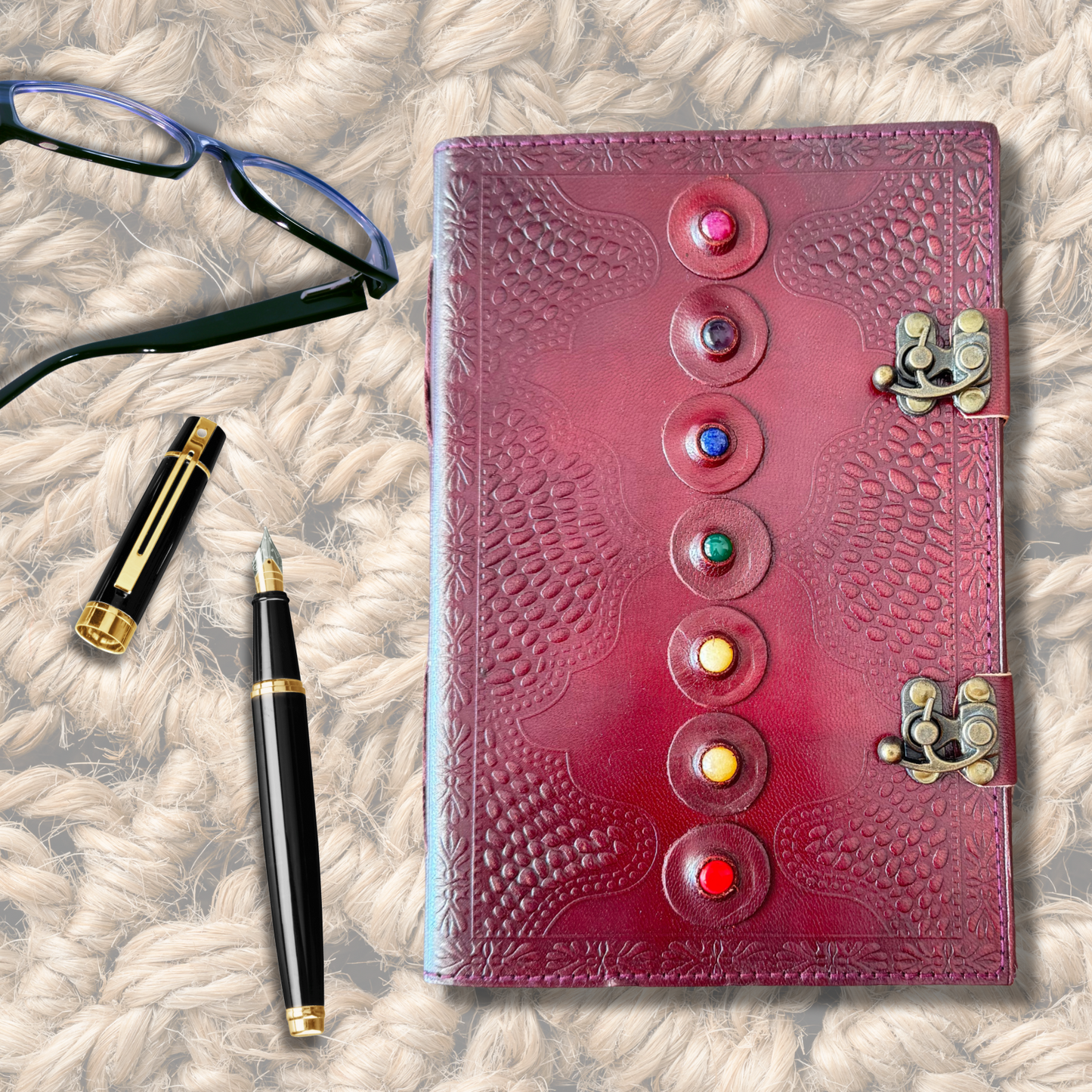 Seven Stone Leather Journal on a jute rug background with galsses and a fountain ink pen on the side of the journal.