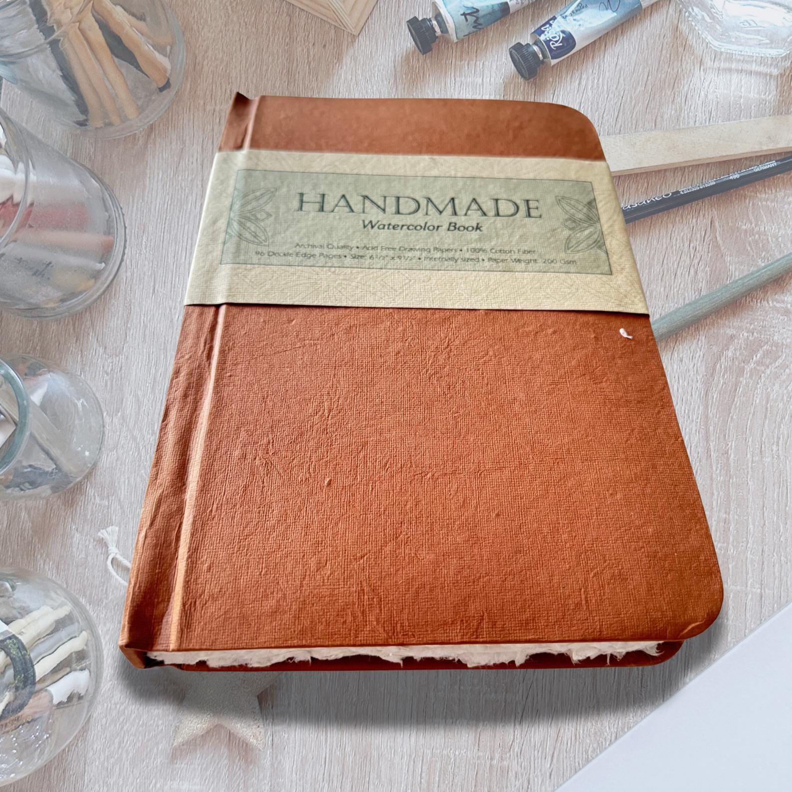 Watercolour Colouring Book on an asthetic table with painitng brushes and water color paint.
