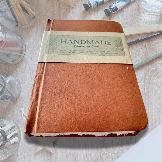 Watercolour Colouring Book on an asthetic table with painitng brushes and water color paint.