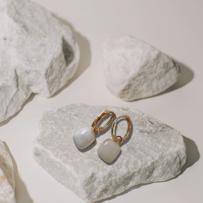 Alba Square Dangle Earrings on a white stone rock