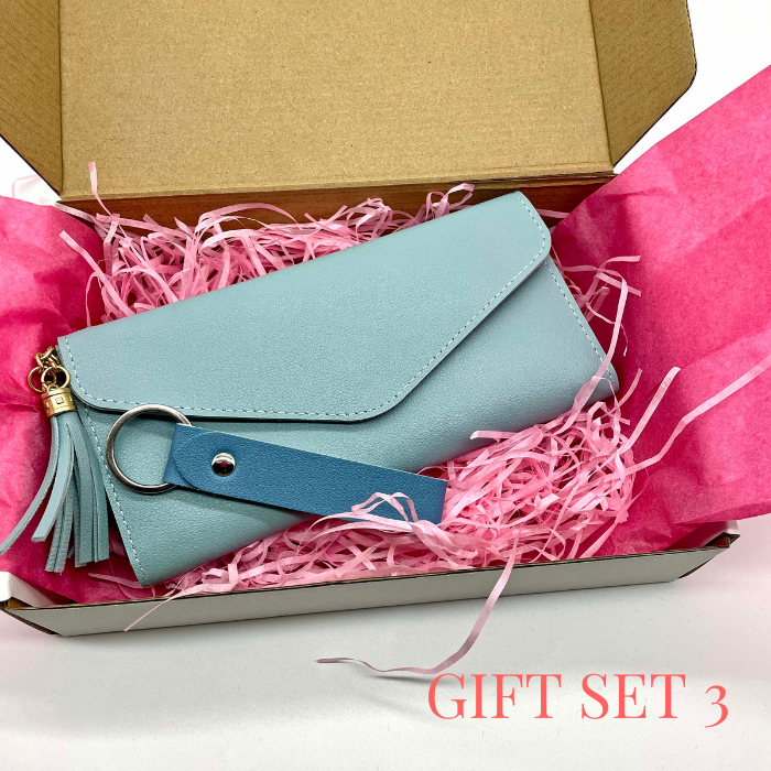 Acquamarine leather wallet and leather keychain beautiful packed in a gift box with pink tissue paper and tissue shreds.