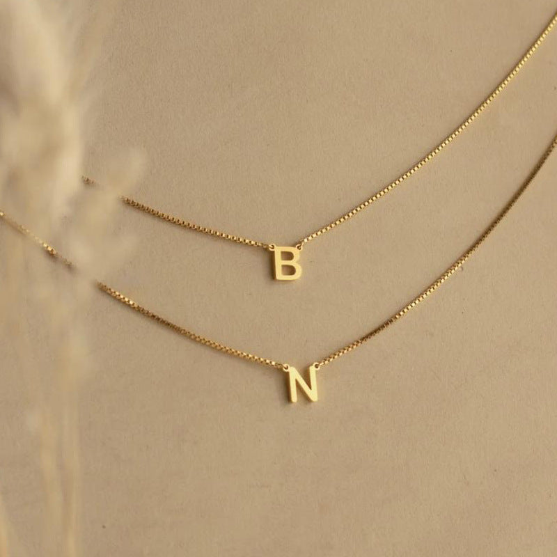 Delaney personalized gold necklace name in letters B and N on plain background
