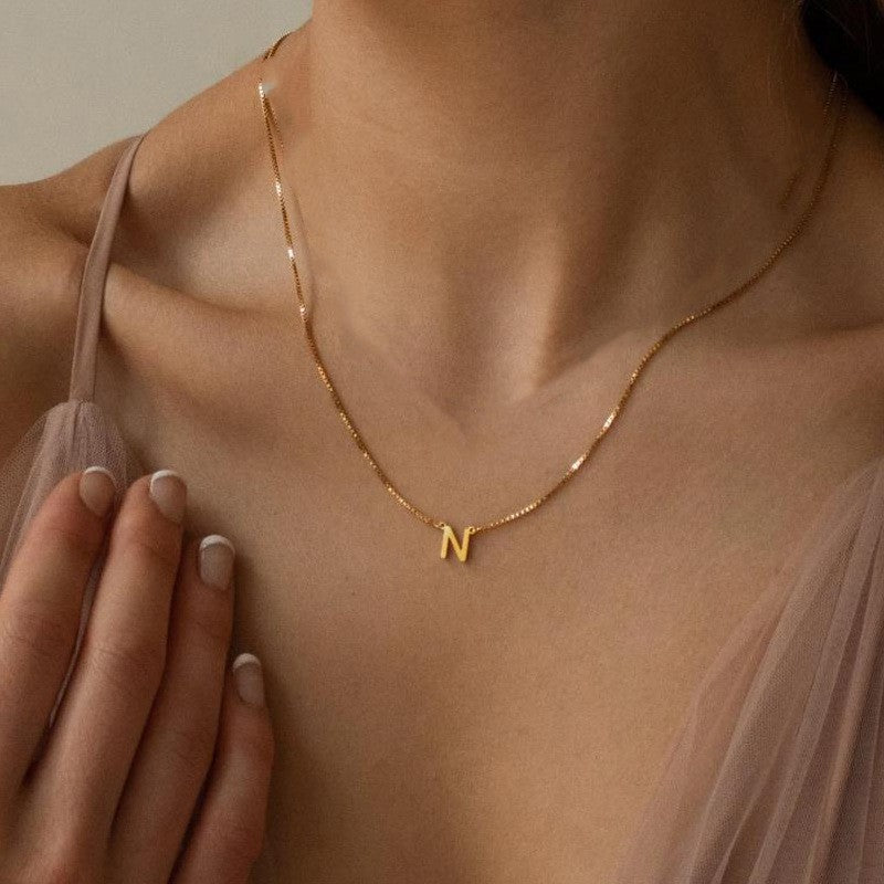 A woman wearing the Delaney Personalised Necklace Initia in gold in the letter N