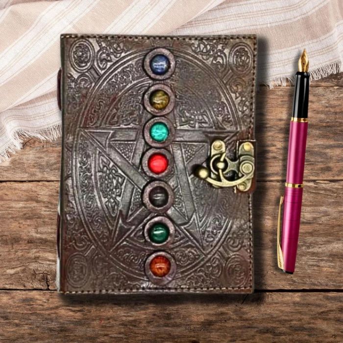 Brown leather journal with 7 stones on an asthetic backgroudn with a fountain pen on the side