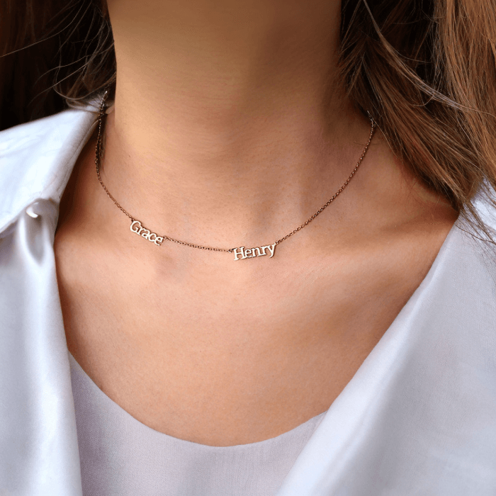  A woman wearing the Adele multiple name necklace in rose gold with 2 names