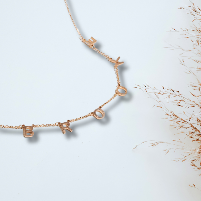 Displaying the Amara initial necklace gold in rose gold finish with the initials B R O O K E. 