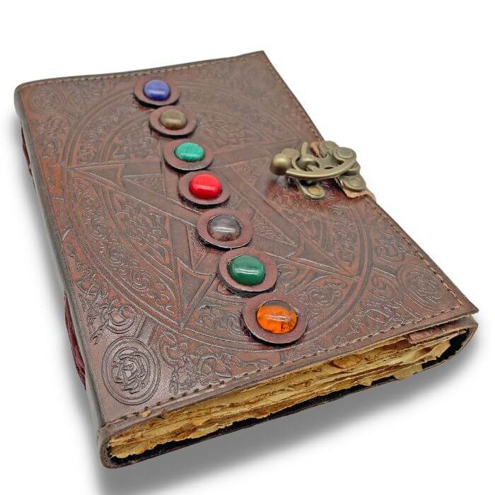 Leather journal handmade with brass lock placed on a white background. 